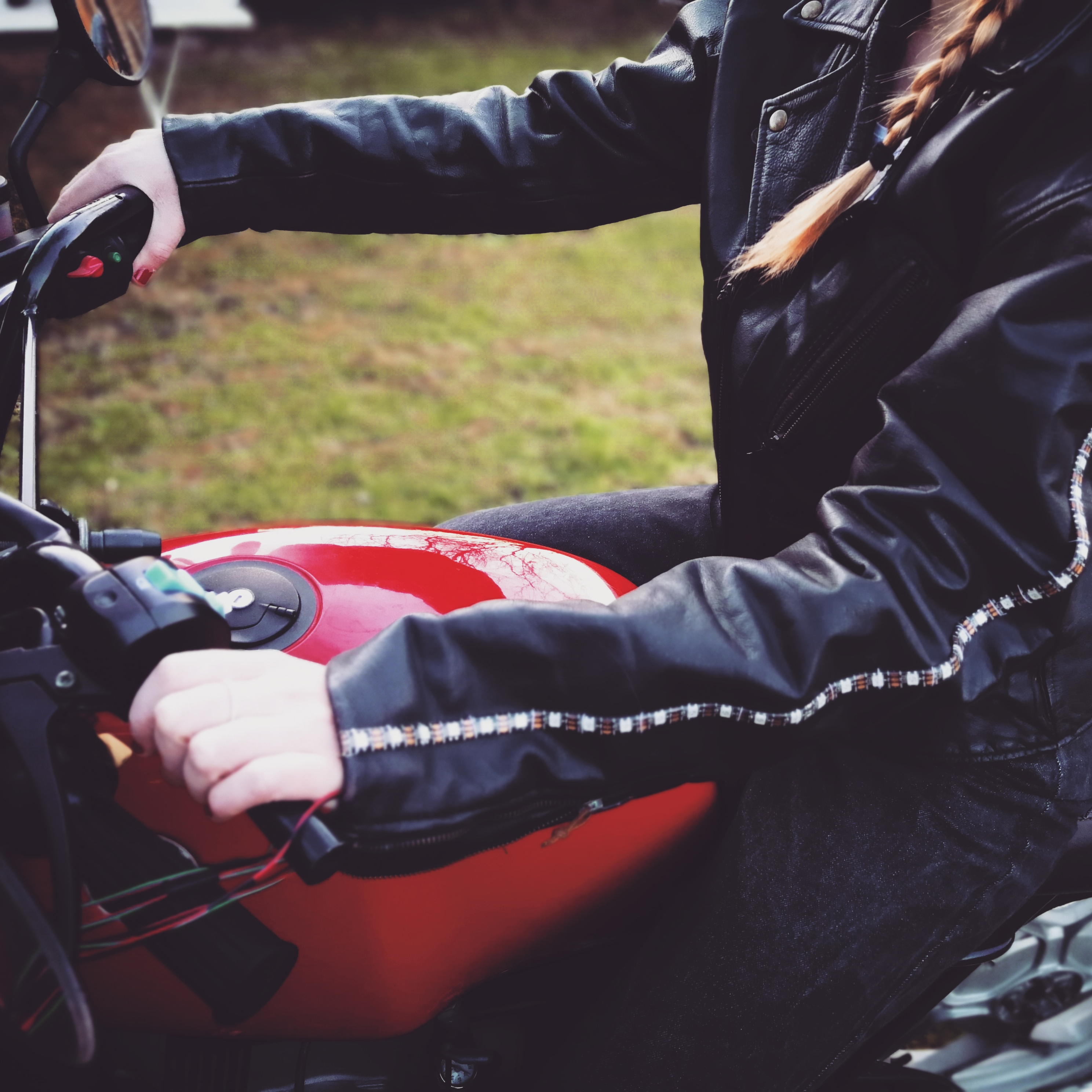 Foto der Motorradjacke von der Seite, die von einer jungen Frau auf einem Motorrad getragen wird.